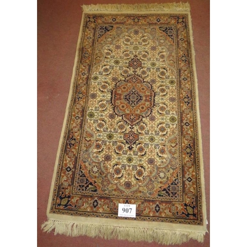 907 - A Persian design rug, central motif, surrounded by repeat fawn, cream & brown. 176cm x 94cm (approx)... 