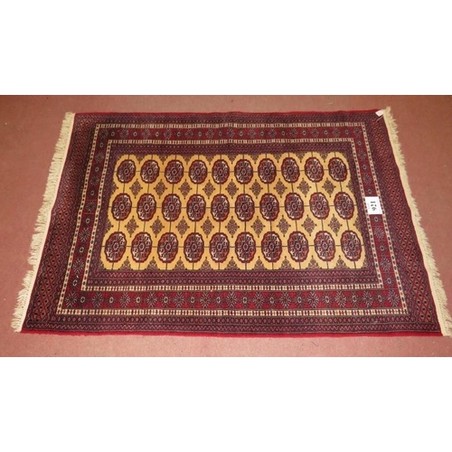 912 - A Persian rug, central repeat pattern on cream ground on red, with wide borders. 181cm x 127cm (appr... 