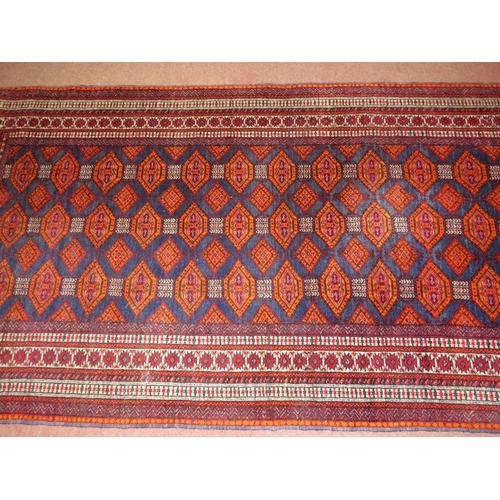 914 - A 20th century Persian rug, central field of repeat pattern, orange/red on blue ground. 180cm x 96cm... 