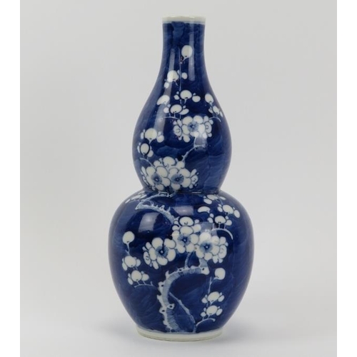 1 - A Chinese blue and white porcelain double gourd vase, 19th century. With blossoming prunus decoratio... 