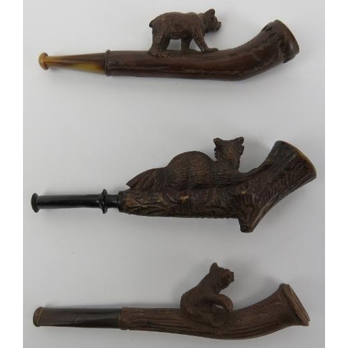 100 - Three Black Forest carved cheroot pipes. Two surmounted with bears and the other with a recumbent fo... 