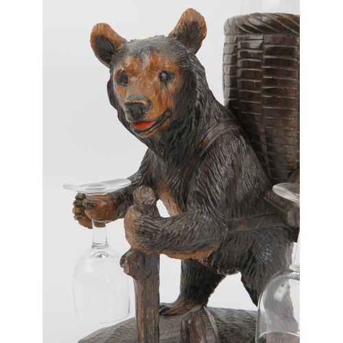 101 - A Black Forest carved wood bear drinks decanter set. Modelled depicting a hiking bear carrying a bas... 