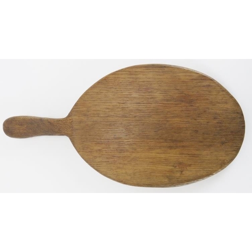 21 - A Robert ‘Mouseman’ Thompson English oak cheeseboard. Of oval form with the trademark mouse carved i... 