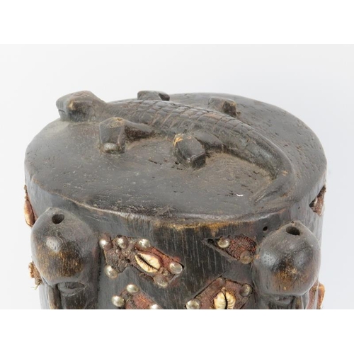 259 - Tribal Art: A West African carved wood reliquery box and cover. With masks and a crocodile carved in... 