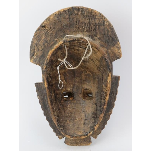 264 - Tribal Art: An African Ivory Coast carved and painted wood mask, Baule/Guro people. 33.5 cm height. ... 