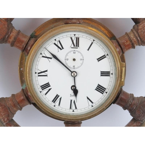 27 - Maritime: A Sestrel bulkhead clock set within an oak and brass six spoke ship’s wheel, 20th century.... 