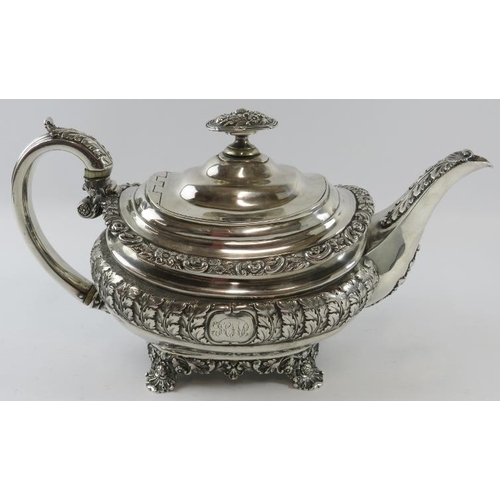 318 - A late George III ornate silver teapot with acanthus and scallop decoration standing on a four foote... 