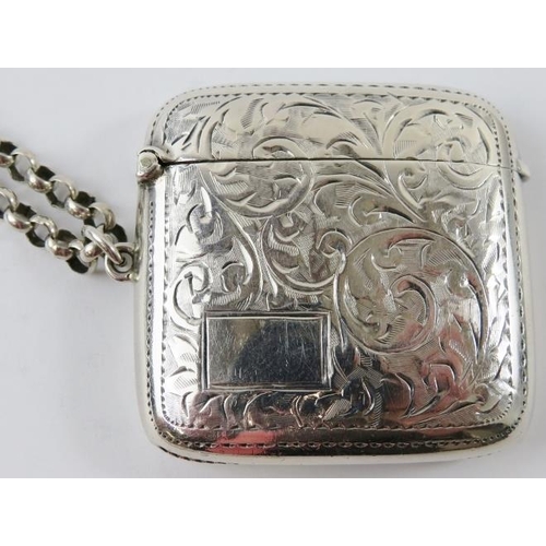 324 - An engraved silver vesta case on an unmarked white metal keep chain. Vesta case hallmarked for Birmi... 