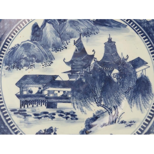 96 - A Chinese blue and white porcelain charger, 19th century. Painted depicting a lakeside pavilion with... 