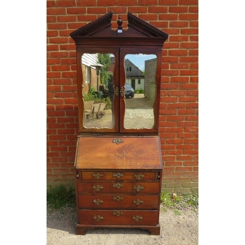 703 - An 18th century mahogany bureau bookcase, the broken pediment with turned centre finial and dentil c... 