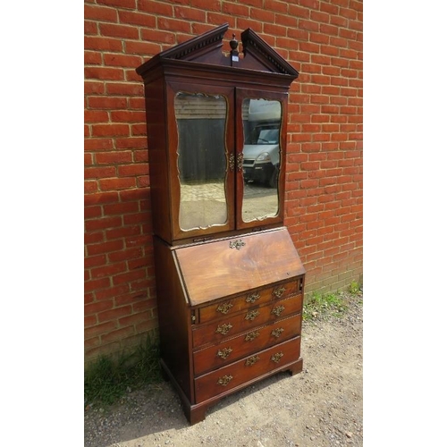 703 - An 18th century mahogany bureau bookcase, the broken pediment with turned centre finial and dentil c... 