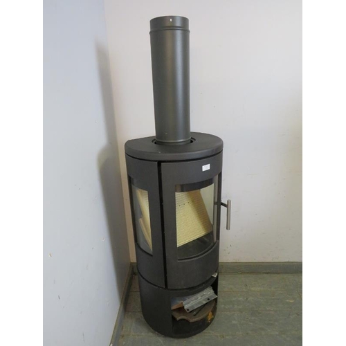 707 - A contemporary cast-iron multifuel stove by Morso (model 7443) having a curved glass door with stain... 