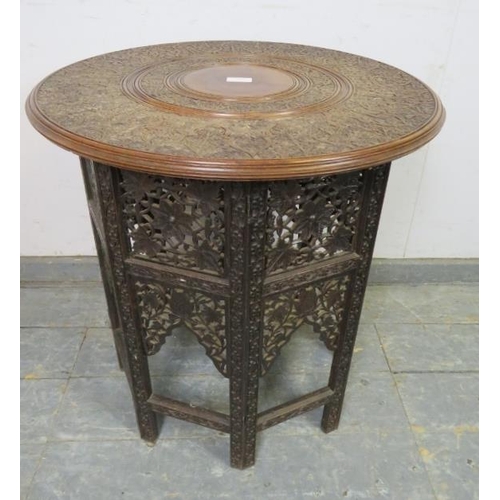 709 - An early 20th century Angle Indian hardwood occasional table, the circular top with relief carving d... 