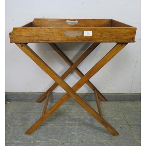 711 - An early 20th century walnut butler’s tray on stand, the galleried tray with pierced handles to eith... 