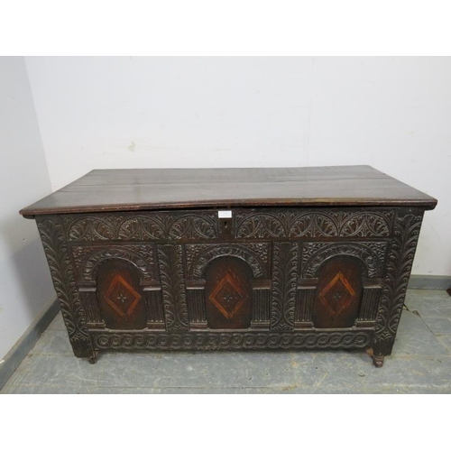 713 - A late 17/early 18th century oak panelled coffer, having internal candle box, the front profusely ca... 