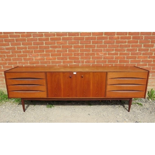 717 - A mid-century Danish teak sideboard, the double doors with turned wooden handles, opening onto a hei... 