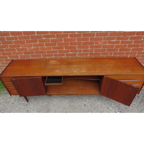 717 - A mid-century Danish teak sideboard, the double doors with turned wooden handles, opening onto a hei... 