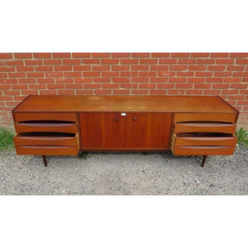 717 - A mid-century Danish teak sideboard, the double doors with turned wooden handles, opening onto a hei... 