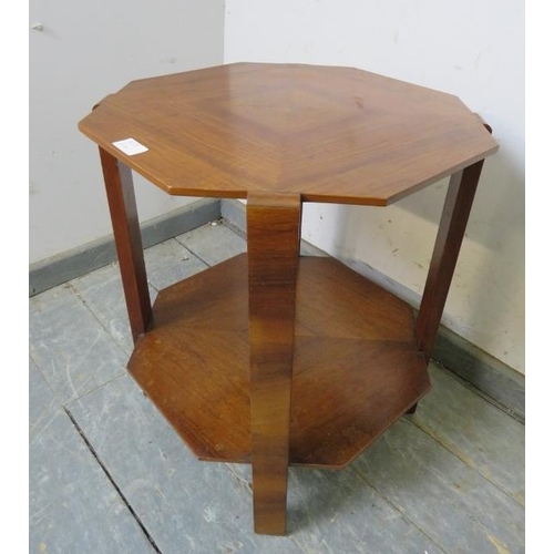 720A - An Art Deco Period walnut octagonal two-tier table, the quarter veneered top with swing-out brass as... 