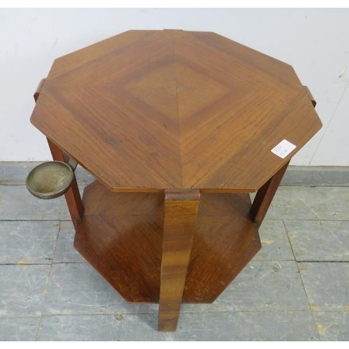 720A - An Art Deco Period walnut octagonal two-tier table, the quarter veneered top with swing-out brass as... 