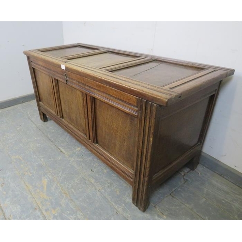 721 - An early 18th century medium oak panelled coffer, retaining the original hinges, on stile supports. ... 