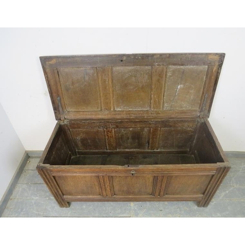 721 - An early 18th century medium oak panelled coffer, retaining the original hinges, on stile supports. ... 