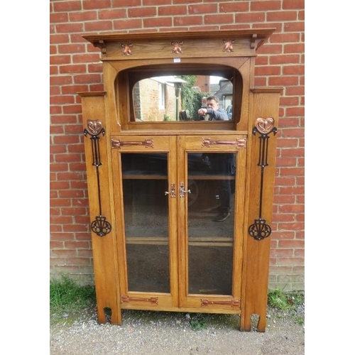 723 - An Arts & Crafts light oak glazed cabinet in the manner of Glasgow school, the stepped cornice above... 