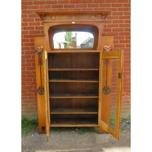 723 - An Arts & Crafts light oak glazed cabinet in the manner of Glasgow school, the stepped cornice above... 