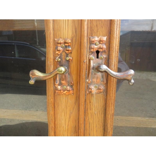 723 - An Arts & Crafts light oak glazed cabinet in the manner of Glasgow school, the stepped cornice above... 