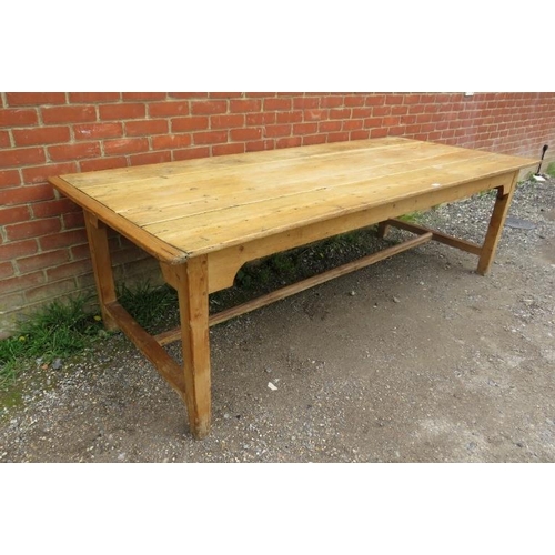 724 - An antique pine refectory style farmhouse table, the planked top on square supports united by an ‘H’... 