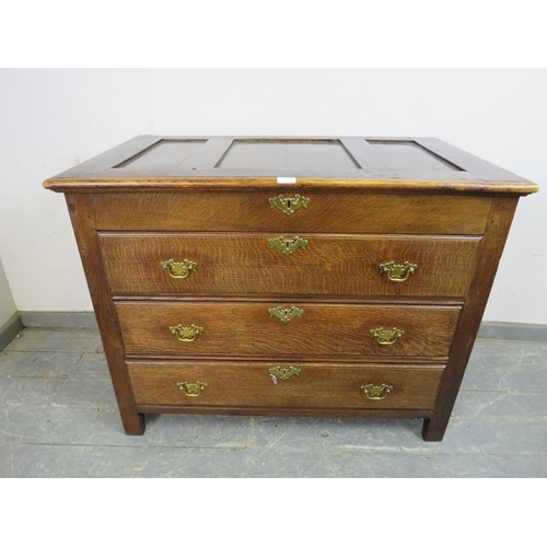 727 - An antique oak chest in the 18th century taste, the panelled lid opening onto a shallow compartment,... 