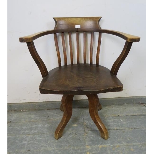 737 - An Edwardian elm captain’s swivel desk chair, on four shaped supports. 
H79cm W65cm D48cm (approx).
... 