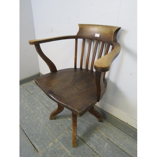 737 - An Edwardian elm captain’s swivel desk chair, on four shaped supports. 
H79cm W65cm D48cm (approx).
... 