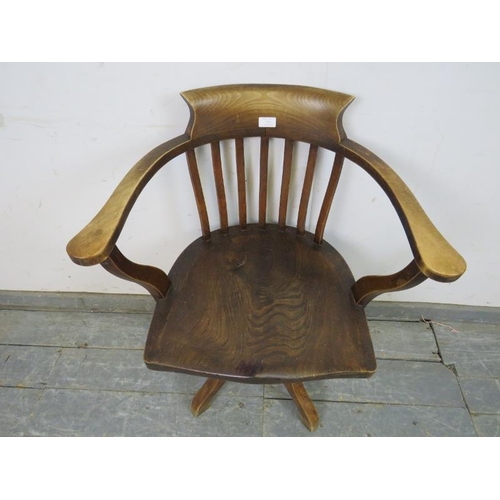 737 - An Edwardian elm captain’s swivel desk chair, on four shaped supports. 
H79cm W65cm D48cm (approx).
... 