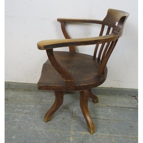 737 - An Edwardian elm captain’s swivel desk chair, on four shaped supports. 
H79cm W65cm D48cm (approx).
... 