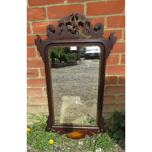 738 - A Georgian mahogany parcel gilt bevelled wall mirror, the shaped and pierced surround with a carved ... 