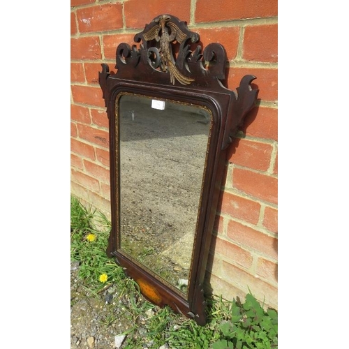 738 - A Georgian mahogany parcel gilt bevelled wall mirror, the shaped and pierced surround with a carved ... 