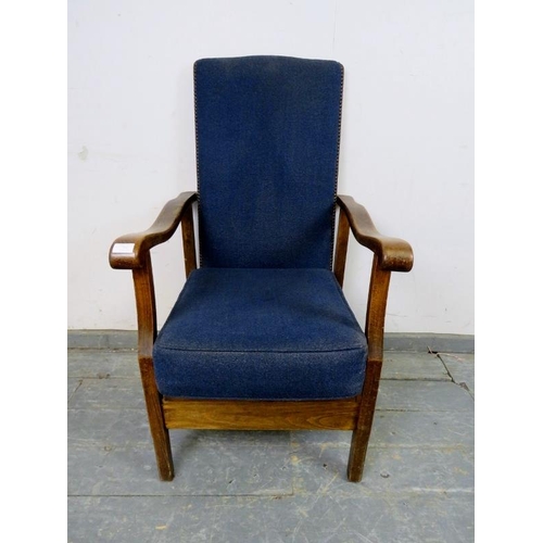 742 - A 1920s oak reclining open-sided armchair, upholstered in navy material with brass studs, the shaped... 