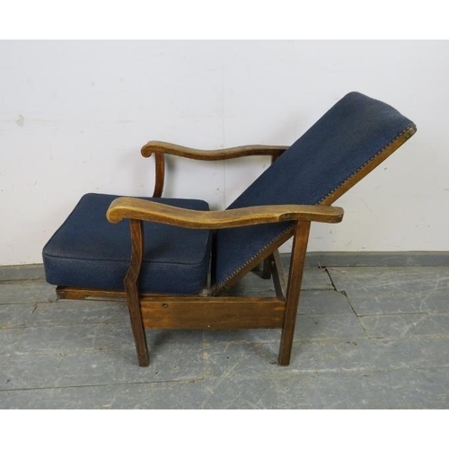 742 - A 1920s oak reclining open-sided armchair, upholstered in navy material with brass studs, the shaped... 