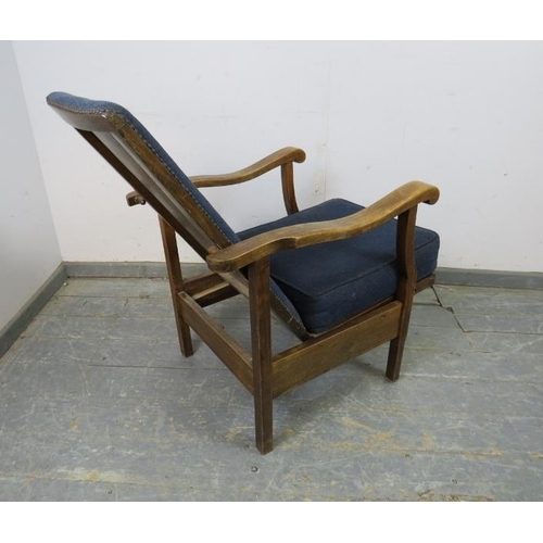 742 - A 1920s oak reclining open-sided armchair, upholstered in navy material with brass studs, the shaped... 