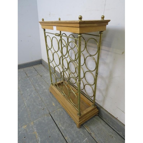 765 - A vintage beech and brass wine rack (capacity 16 bottles) with brass ball finials, on a stepped plin... 