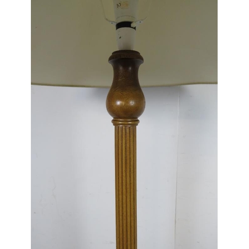 766 - A vintage walnut standard lamp, the tapering fluted and carved column on a circular plinth base with... 