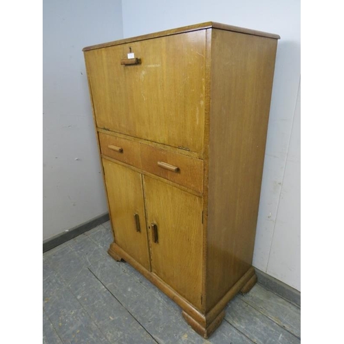 774 - A vintage Art Deco Revival light oak drinks cabinet, the top section with fall front and rising lid ... 