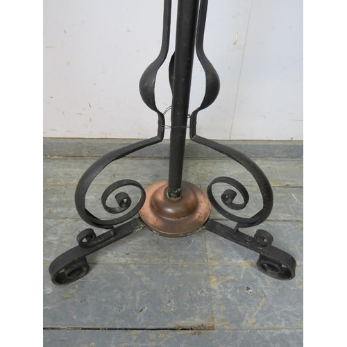 784 - An Art Nouveau floor-standing wrought iron and copper oil lamp, on scrolled tripod supports. 
H165cm... 