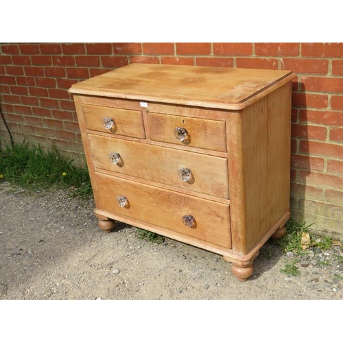 787 - An antique pine chest, housing two short above two long graduated drawers with fluted glass knob han... 