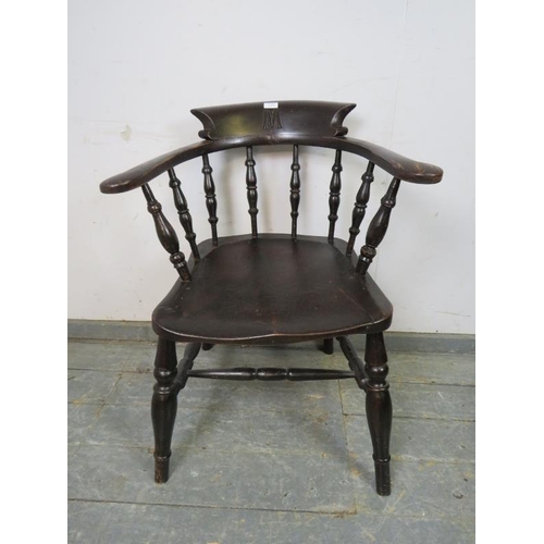 790 - A turn of the century ebonised captain’s chair, carved with the initial ‘M’ the scrolled arms joined... 