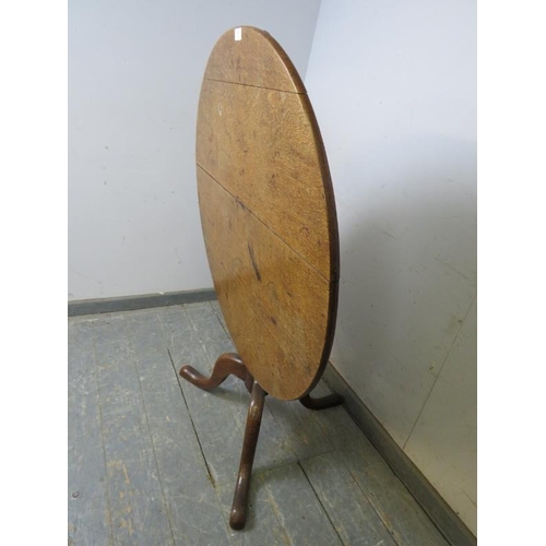 793 - A 19th century medium oak tilt-top supper table, on a ring turned column with splayed tripod support... 