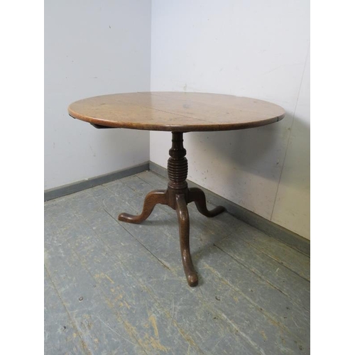 793 - A 19th century medium oak tilt-top supper table, on a ring turned column with splayed tripod support... 