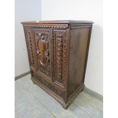 810 - A 17th century Italian oak side cabinet, the chip carved frieze above profuse relief carved decorati... 