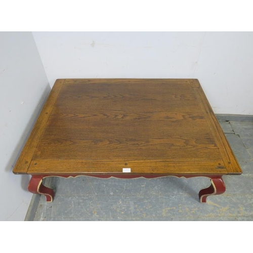 812 - A reproduction oak rectangular coffee table, the burgundy painted base with shaped frieze above ogee... 